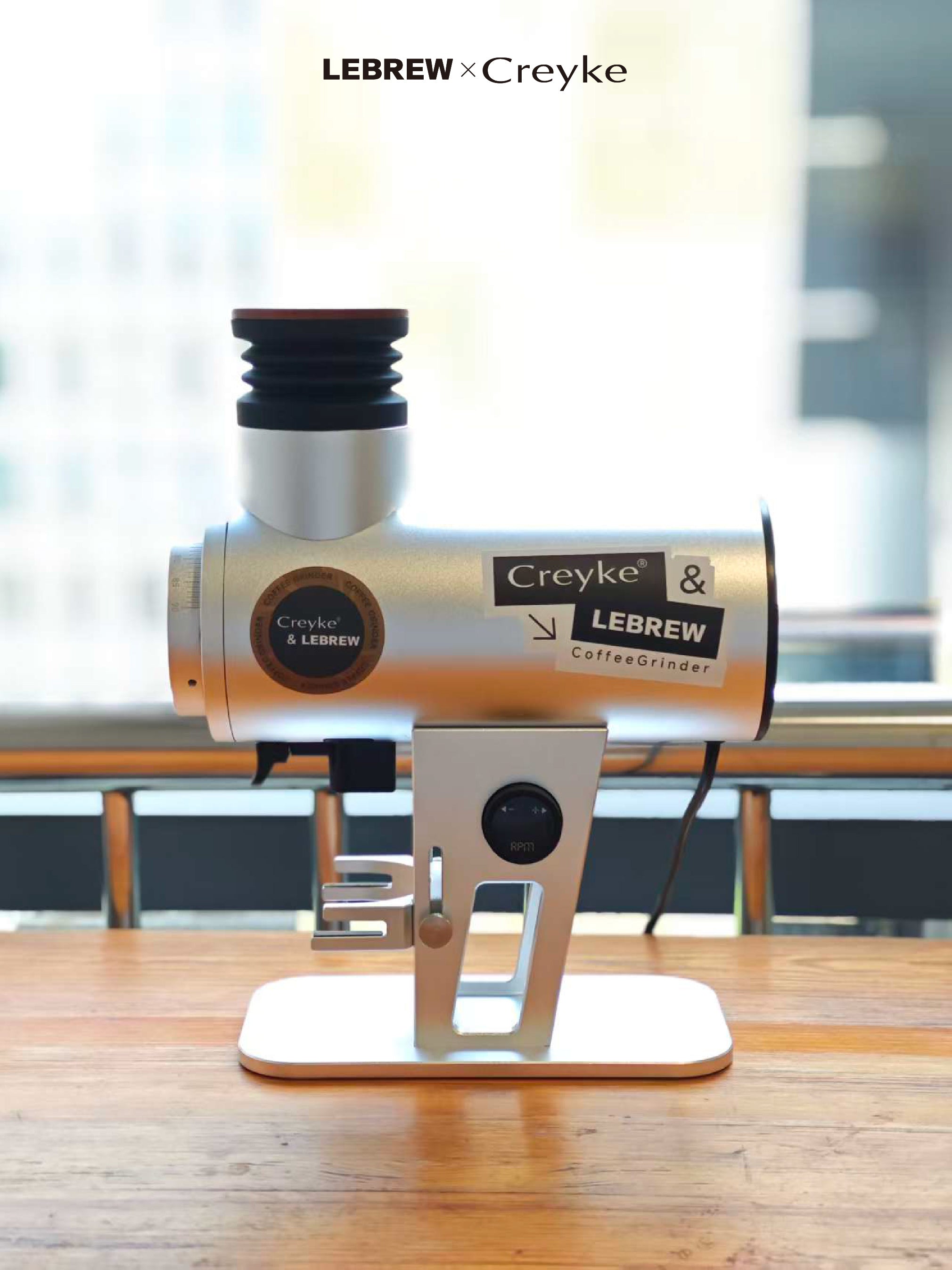 Silver CF80V coffee grinder with LeBrew and Creyke branding on a wooden table.
